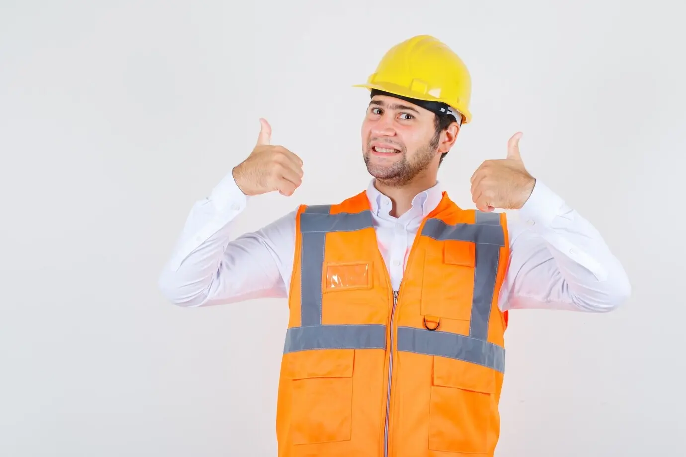 Bauarbeiter im Hemd, in Uniform, zeigt Daumen hoch und sieht glücklich aus, Frontalansicht.